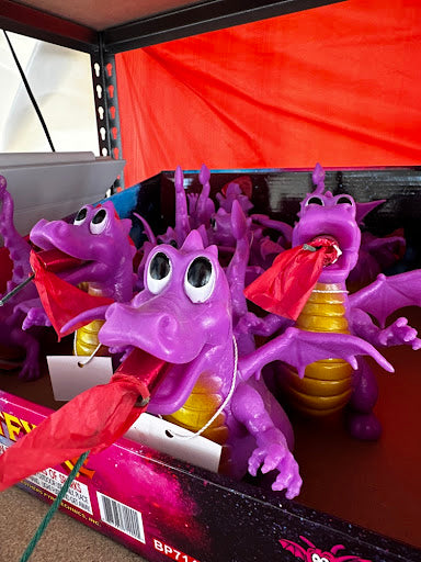 Purple dragon toys with red tongues on a display stand.