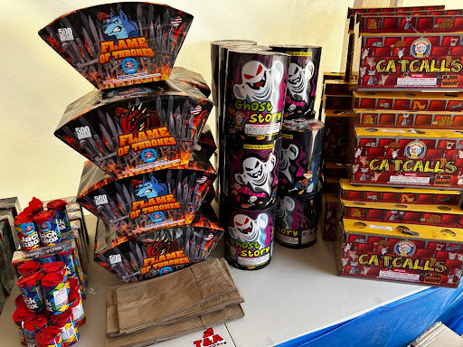 Assorted fireworks packages including 'Flame of Thrones' and 'Catcalls' on a table.